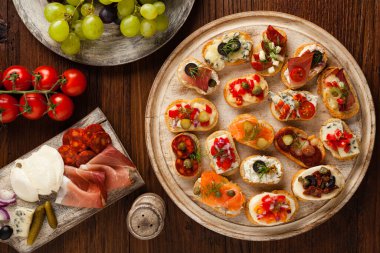 Ahşap arka planda farklı malzemelerle Crostini. Lezzetli aperatifler. Üst görünüm.
