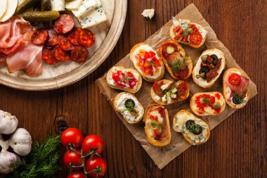 Ahşap arka planda farklı malzemelerle Crostini. Lezzetli aperatifler. Üst görünüm.