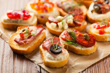 Ahşap arka planda farklı malzemelerle Crostini. Lezzetli aperatifler. Ön görünüm.