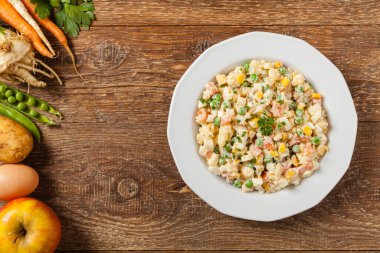 Mayonezli sebzeli geleneksel salata. Ahşap arka plan. Üst görünüm.