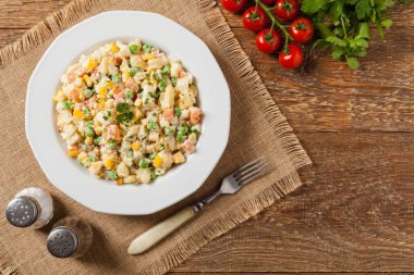 Mayonezli sebzeli geleneksel salata. Ahşap arka plan. Üst görünüm.