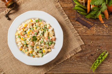 Mayonezli sebzeli geleneksel salata. Ahşap arka plan. Üst görünüm.