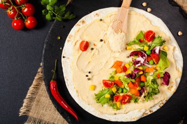 Sebzeli tortilla ve nohutlu humus. Üst Manzara. Siyah arkaplan. 