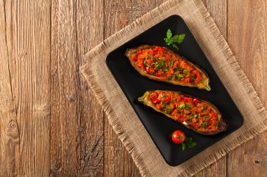 Siyah tabakta patlıcan dolması. Ahşap arka plan. Üst görünüm.