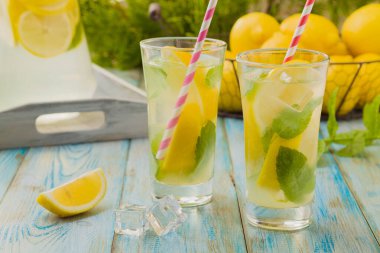 Nane şekerli limonata ve bir bardakta servis edilen ahşap bir masada pipetle..