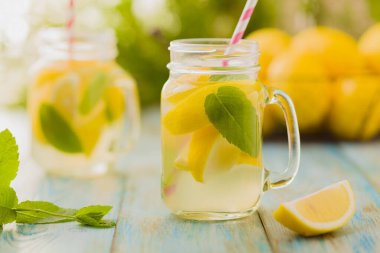 Nane şekerli limonata ve bir kavanozda servis edilmiş tahta bir masada pipetle..