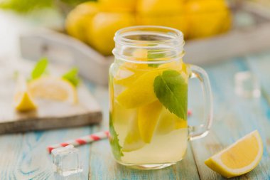 Nane şekerli limonata ve bir kavanozda servis edilmiş tahta bir masada pipetle..