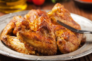 Fırında kanat, sos ya da fırında patates ile servis edilir. Ön görünüm.