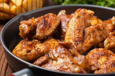 Fırında kanat, sos ya da fırında patates ile servis edilir. Ön manzara. Kapat..