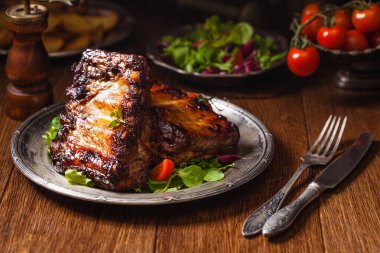 Kızarmış pirzola, eski bir tabakta servis edilir. Fron manzaralı. Koyu veya kel arkaplan.