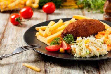 Tavuk Kiev (de Volaille pirzolası) patates kızartması ve salata ile. Ön görünüm.