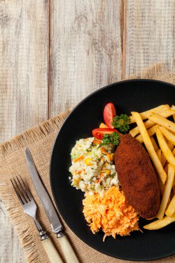 Tavuk Kiev (de Volaille pirzolası) patates kızartması ve salata ile. Üst görünüm.