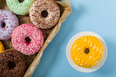 Mavi arka planda renkli çörekler. Üst görünüm