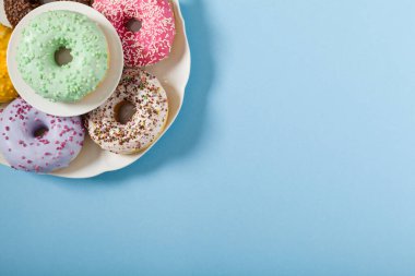 Mavi arka planda renkli çörekler. Üst görünüm