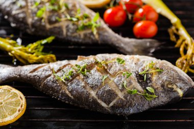 Kızarmış sebze ve limonla birlikte ızgara balık. Ön görünüm.