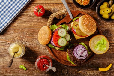 Ev yapımı, peynirli ve sebzeli sığır burger. Üst görünüm.