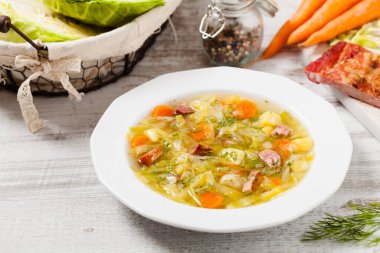 Ev yapımı lahana çorbası, füme pirzola ile pişirilmiş. Ön görünüm.