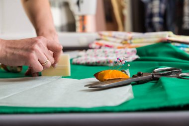 Dikiş atölyesi. Dikiş battaniyesini hazırlıyorum. Materyali çiziyorum. Terzi kesmek için bir şablon çizer.