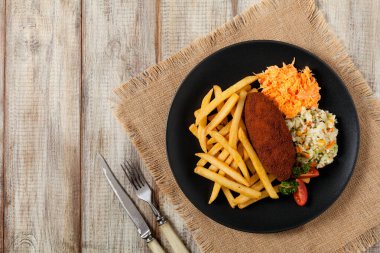 Tavuk Kiev (de Volaille pirzolası) patates kızartması ve salata ile. Üst görünüm.