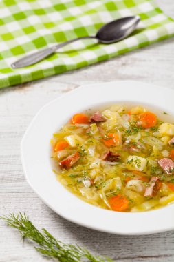 Ev yapımı lahana çorbası, füme pirzola ile pişirilmiş. Ön görünüm.