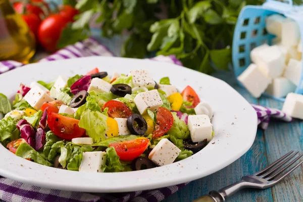 皿の上に新鮮なギリシャのサラダ 青い木の板 — ストック写真