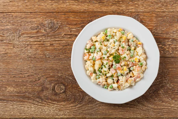 Mayonezli sebzeli geleneksel salata. Ahşap arka plan. Üst görünüm.