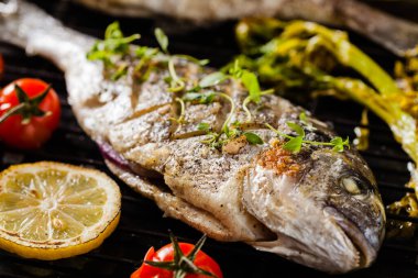 Kızarmış sebze ve limonla birlikte ızgara balık. Ön görünüm.