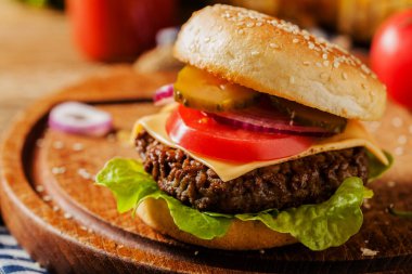 Ev yapımı, peynirli ve sebzeli sığır burger. Ön görünüm.