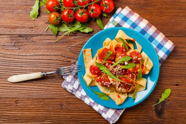 Domates soslu köfteli İtalyan makarnası. Peynir ve roka serpiştirilmiş. Üst görünüm