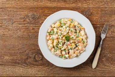 Mayonezli sebzeli geleneksel salata. Ahşap arka plan. Üst görünüm.