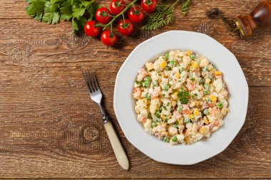 Mayonezli sebzeli geleneksel salata. Ahşap arka plan. Üst görünüm.