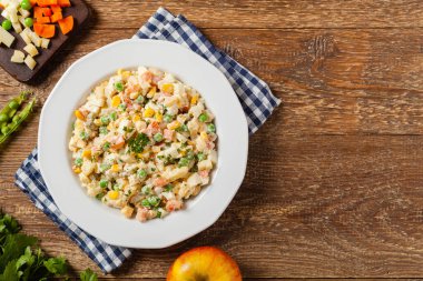 Mayonezli sebzeli geleneksel salata. Ahşap arka plan. Üst görünüm.