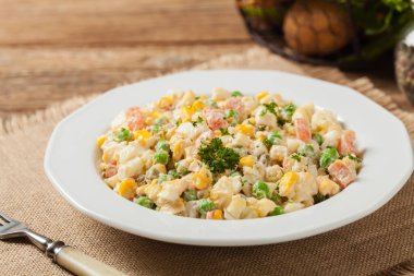 Mayonezli sebzeli geleneksel salata. Ahşap arka plan. Ön görünüm.