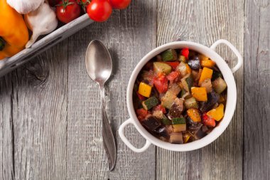 Ratatouille. Klasik yaz sebzeleri Fransız güveci. Ahşap arka plan. Üst görünüm.