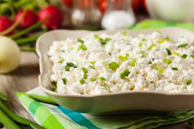 Taze süzme peynir, taze sebze ve kremayla servis edilir. Ön görünüm.