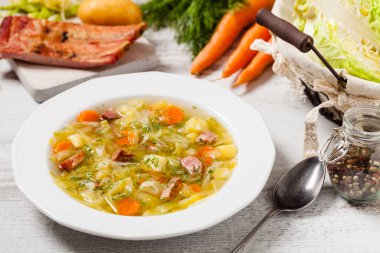 Ev yapımı lahana çorbası, füme pirzola ile pişirilmiş. Ön görünüm.