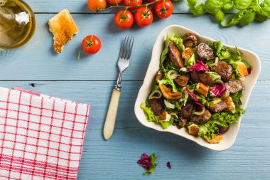 Kızarmış tavuk ciğeri ve tost ile sıcak salata. Üst görünüm.