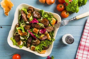 Kızarmış tavuk ciğeri ve tost ile sıcak salata. Üst görünüm.