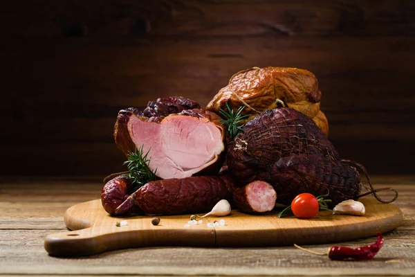 stock image Smoked pork on wooden board. Different types of meat.