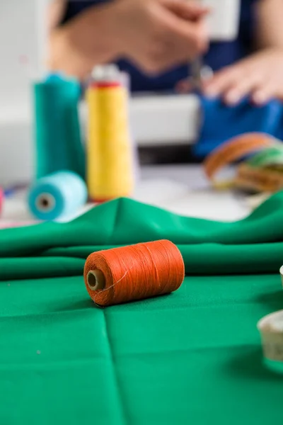 Sewing workshop. Sewing clothes. Closeup on a spool of thread. Photographic concept.