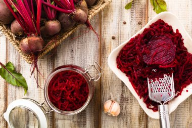 Kavanozda marine edilmiş rendelenmiş pancar kökü. Ahşap arka plan. Üst görünüm.