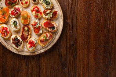Ahşap arka planda farklı malzemelerle Crostini. Lezzetli aperatifler. Üst görünüm.