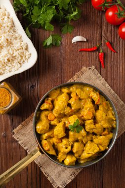 Körili tavuk sosu. Tavada servis edilmiş. Üst Manzara. Doğal ahşap zemin.