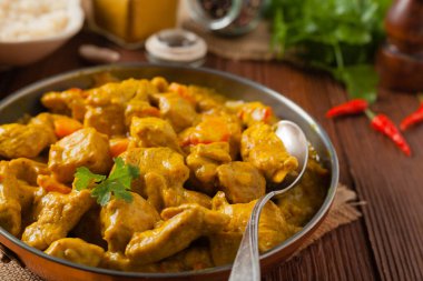 Körili tavuk sosu. Tavada servis edilmiş. Ön manzara. Doğal ahşap zemin.