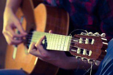 Bir konser sırasında akustik gitar çalan genç bir adam. - Eski renkler..