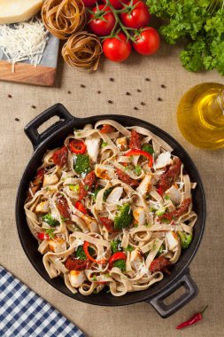 Kızarmış tavuk, kurutulmuş domates ve brokoli ile tam tahıllı tagliatelle makarna. Bir kanepede hizmet etti. Üst görünüm.