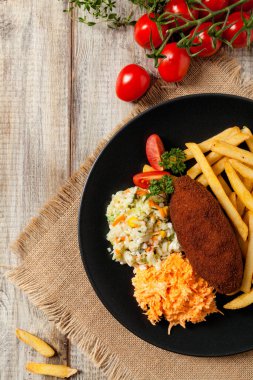 Tavuk Kiev (de Volaille pirzolası) patates kızartması ve salata ile. Üst görünüm.