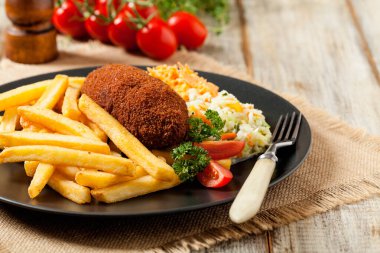 Tavuk Kiev (de Volaille pirzolası) patates kızartması ve salata ile. Ön görünüm.