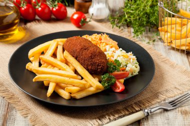 Tavuk Kiev (de Volaille pirzolası) patates kızartması ve salata ile. Ön görünüm.