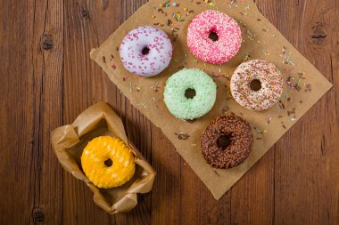 Ahşap arka planda renkli çörekler. Üst görünüm